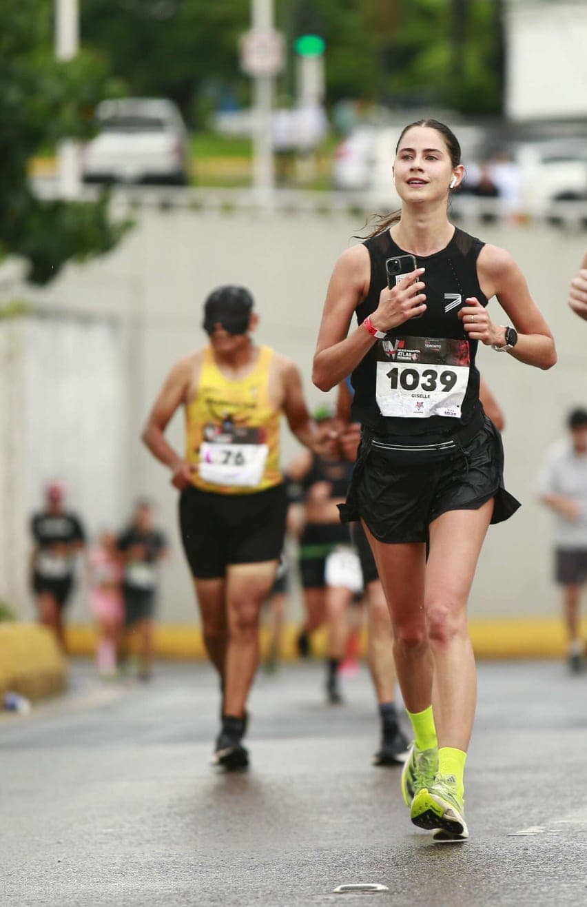 Runner striding through wet streets at the Atlas half marathon