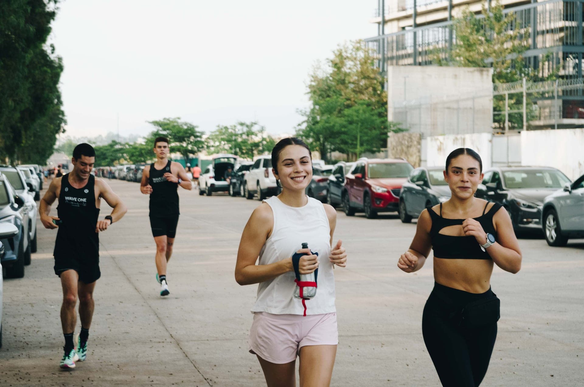 Four Wavers laughing as they cruise through a long run, golden hour bouncing off the parked cars