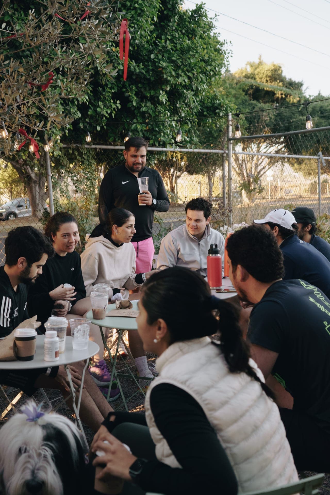 Wavers crowded around outdoor coffee tables, mid-conversation in the early morning light