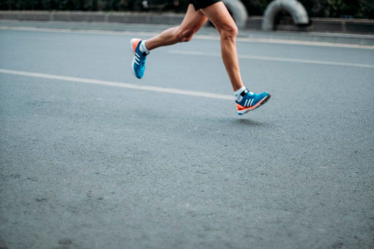 Corredor hidratándose con agua durante una carrera en clima cálido